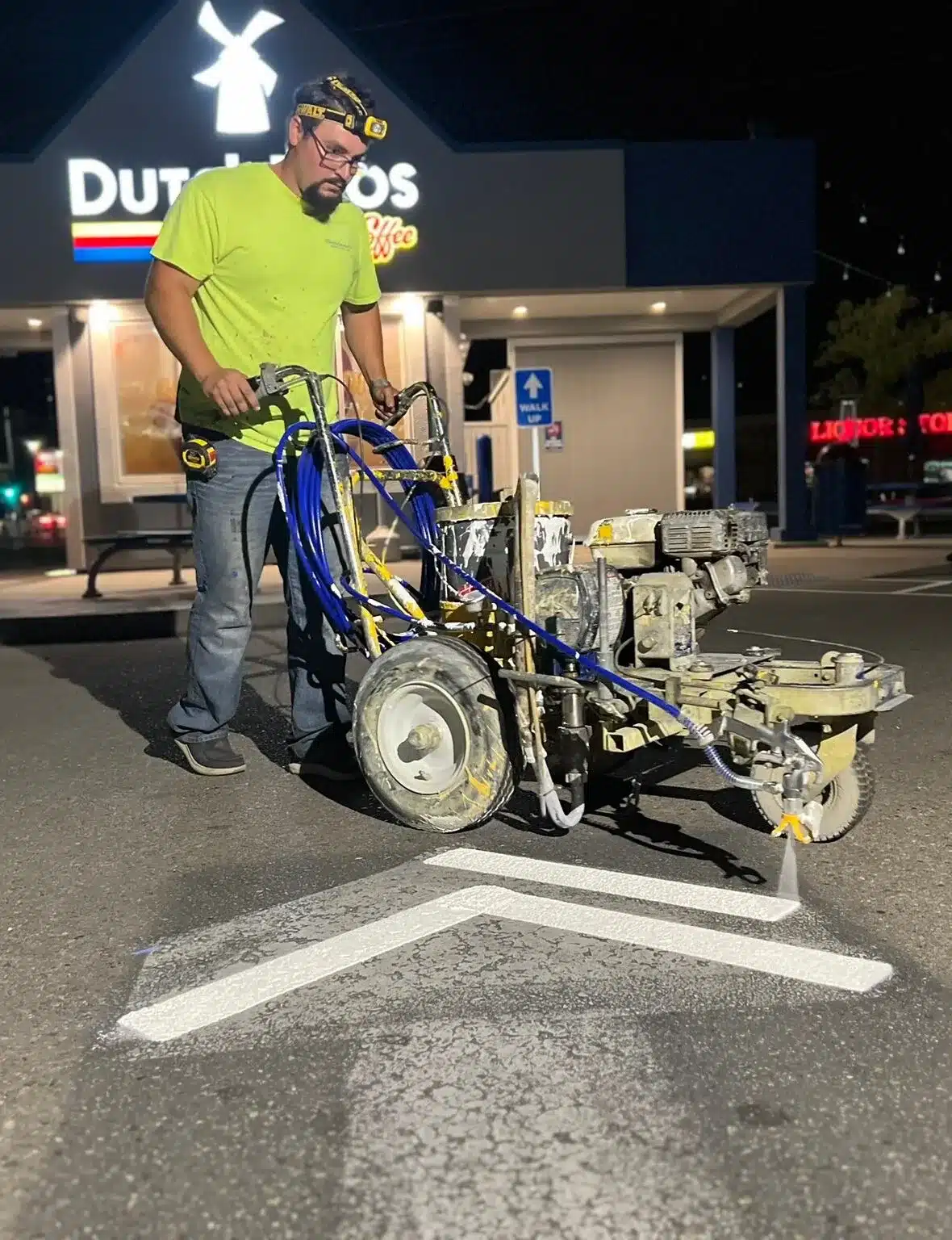 Select Coatings crew striping a Dutch Bros parking lot at night