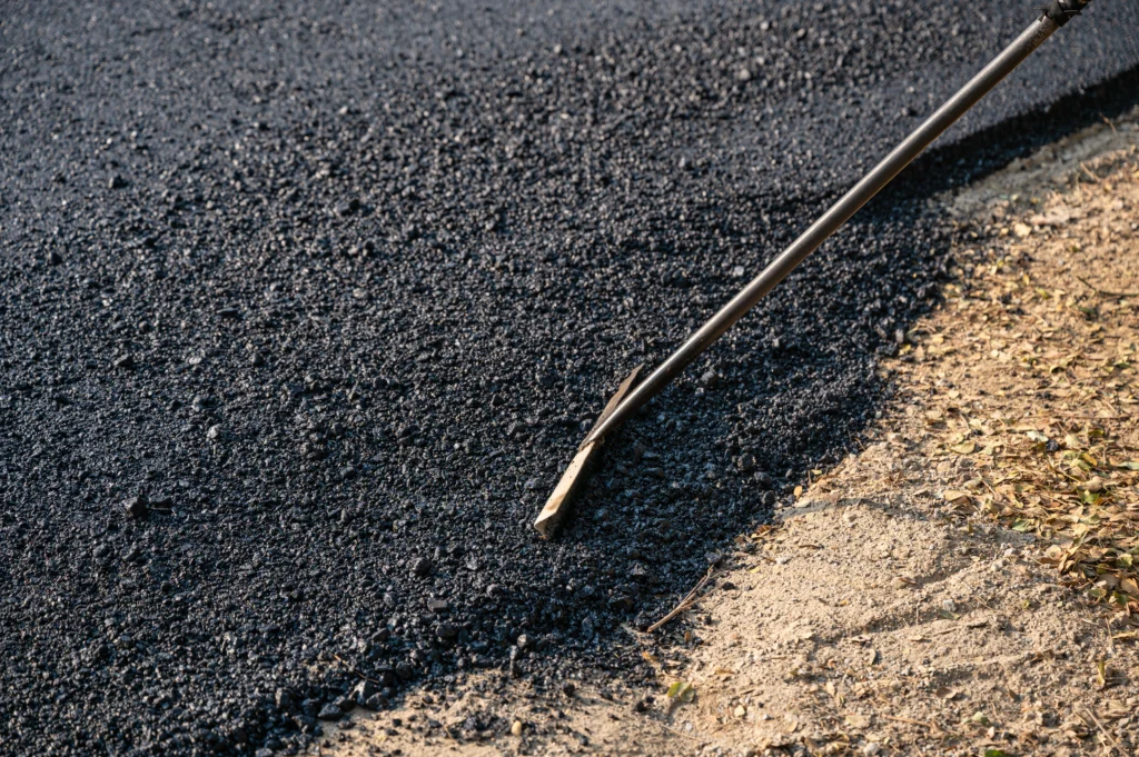 Close-up of freshly laid asphalt in Idaho with construction tool smoothing the surface.