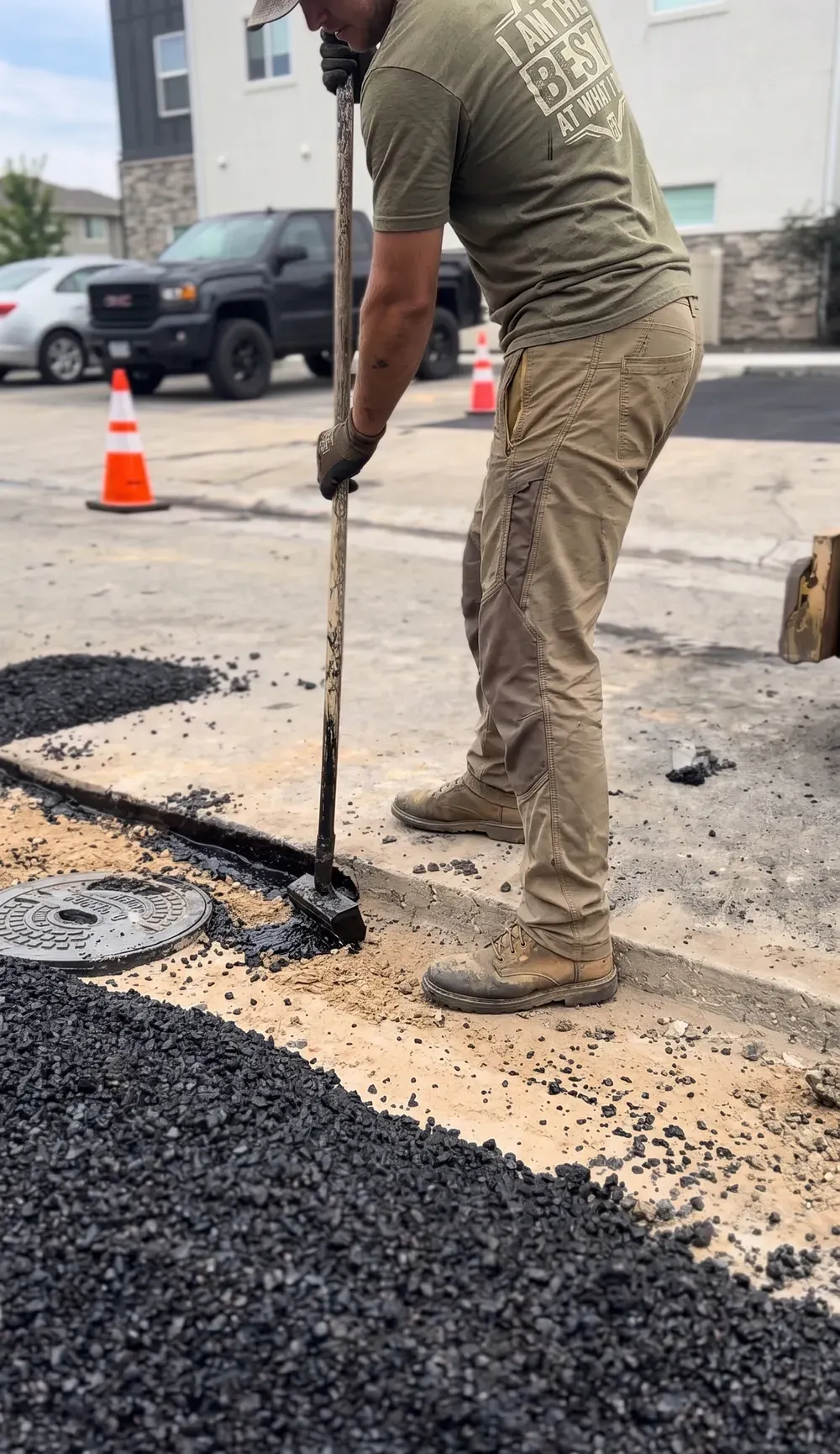 Select Coatings crew raking hot asphalt along a concrete edge in Treasure Valley